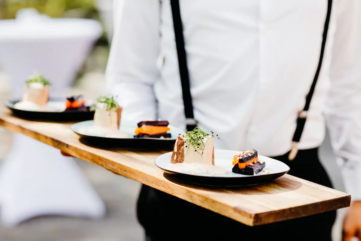 Servicemitarbeiter mit Essen auf Holzbrett